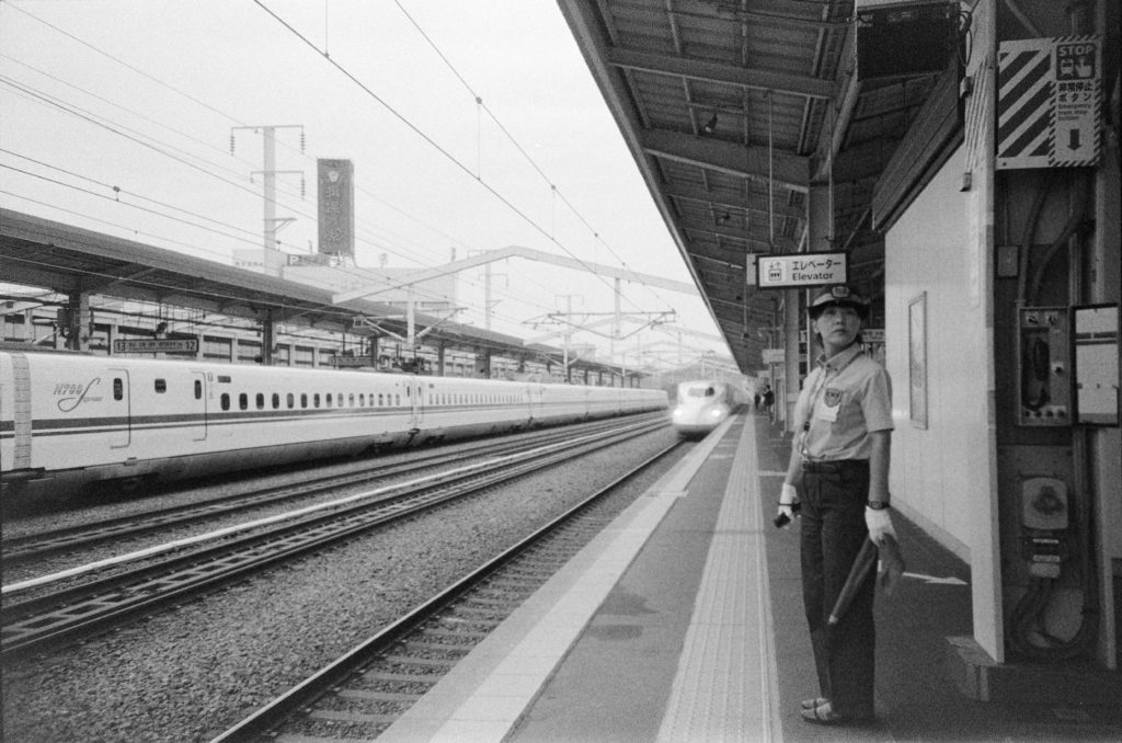 Conductor standing on station platform Himeji, Japan 2024.